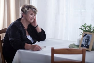 Senior woman looking at dead husbands picture