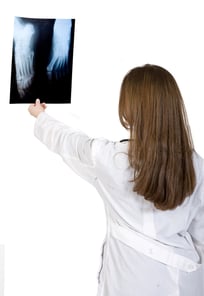 female doctor lokoking at an xray over a white background-1